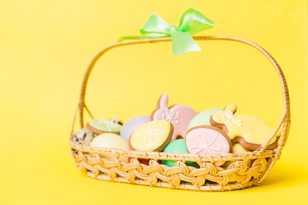 Colorful easter cookies in basket with Multi colors Easter eggs on colored background Pastel color Easter eggs holiday concept with copy space