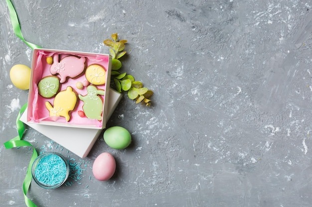 Colorful easter cookies in basket with Multi colors Easter eggs on colored background Pastel color Easter eggs holiday concept with copy space