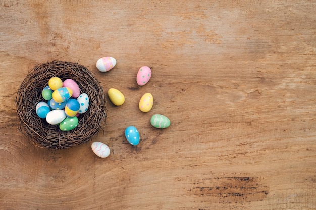 Colorful Easter Egg and nest on a rustic old wood background Above view with copy space