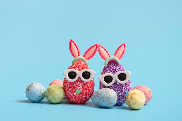 Colorful Easter egg with bunny ears and sunglasses on a blue background. Sale banner, mockup template. copy space