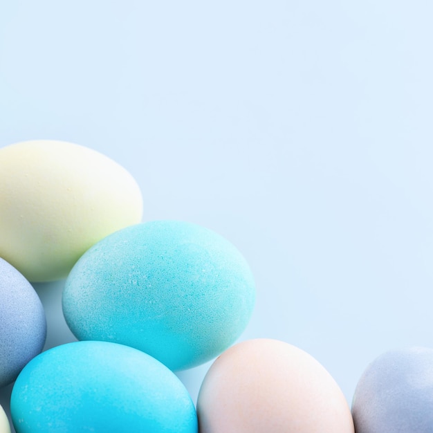 Colorful Easter eggs dyed by colored water isolated on a pale blue background design concept of Easter holiday activity close up copy space