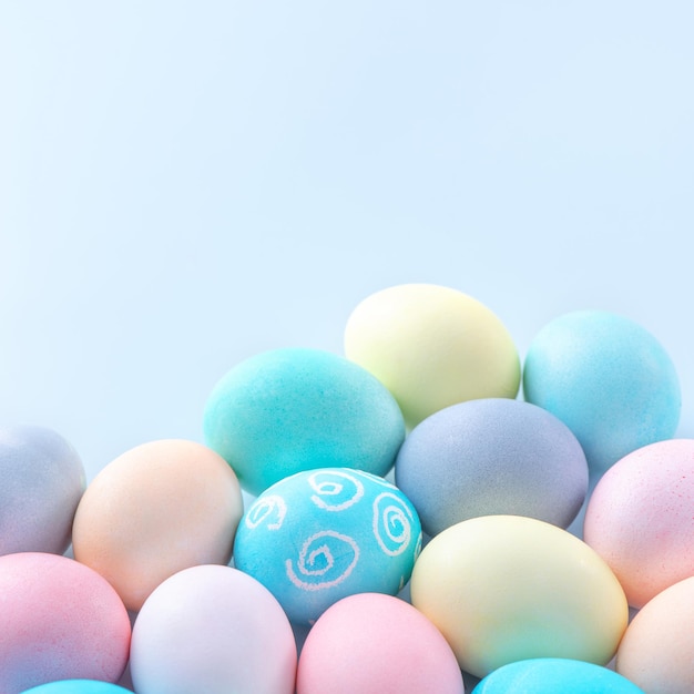 Colorful Easter eggs dyed by colored water isolated on a pale blue background design concept of Easter holiday activity close up copy space