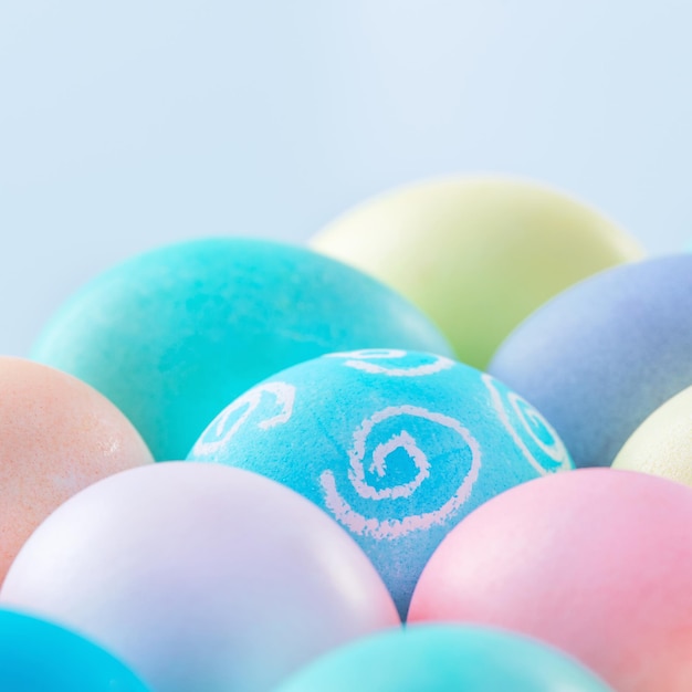 Colorful Easter eggs dyed by colored water isolated on a pale blue background design concept of Easter holiday activity close up copy space