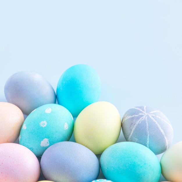 Colorful Easter eggs dyed by colored water isolated on a pale blue background design concept of Easter holiday activity close up copy space