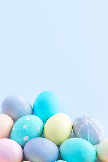 Colorful Easter eggs dyed by colored water isolated on a pale blue background design concept of Easter holiday activity close up copy space