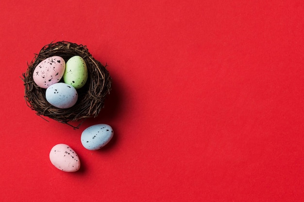 Colorful easter eggs in nest on table background with copy space top view