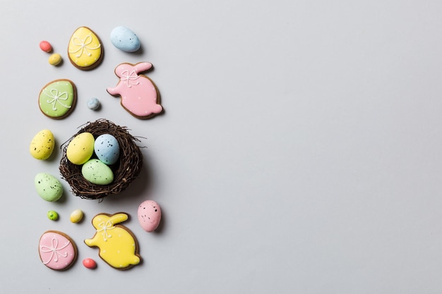 Colorful easter eggs in nest on table background with copy space top view