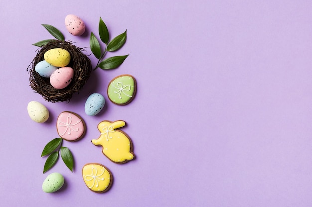 Colorful easter eggs in nest on table background with copy space top view