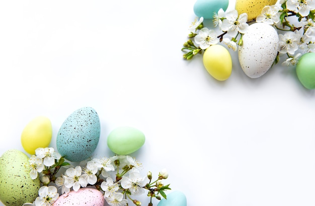 Colorful Easter eggs with spring blossom flowers isolated over white surface