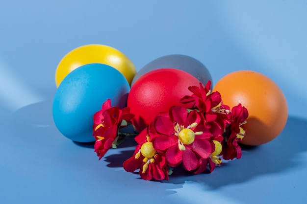 Colorful eggs symbolizing Easter on a colorful background and flowers