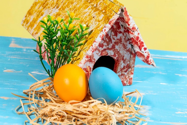 Colorful eggs symbolizing easter with a toy house flowers like a garden