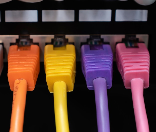 Colorful ethernet cables connected in a row into patch panel.