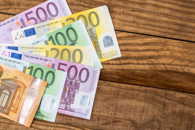 Colorful euro banknotes on wooden desk background