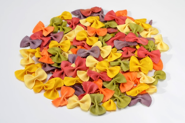 Colorful farfalle pasta with natural extracts isolated on white background