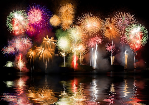 Colorful fireworks. Fireworks are a class of explosive pyrotechnic devices used for aesthetic and entertainment purposes. Visible noise due to low light, soft focus, shallow DOF, slight motion blur