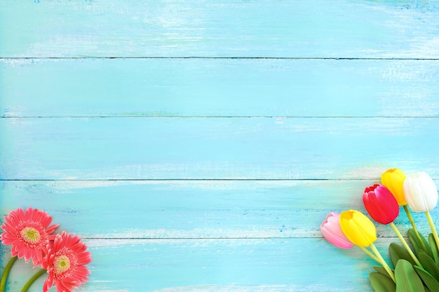 Colorful flowers bouquet on blue wooden background