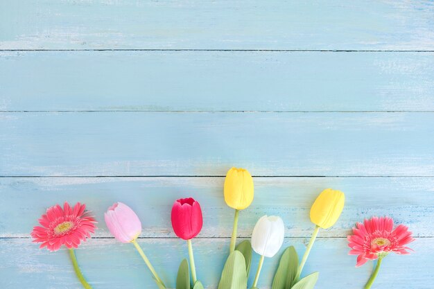 Colorful flowers bouquet on blue wooden background.