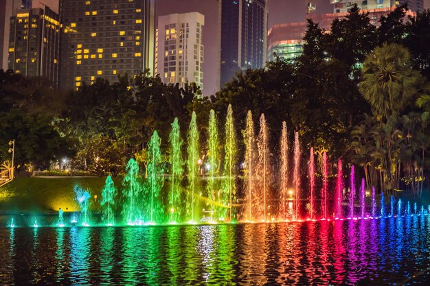 The colorful fountain on the lake at night near by Twin Towers with city on background Kuala Lumpur Malaysia