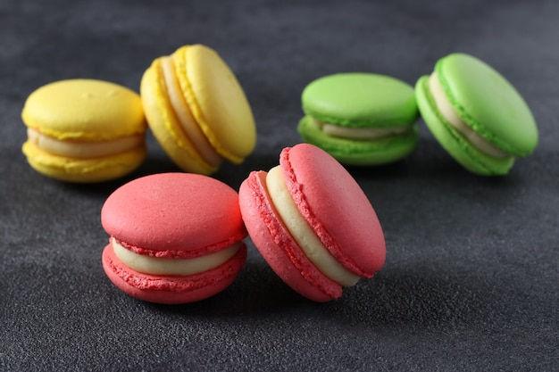 Colorful french macaroons on dark grey background. Close-up. Horizontal format