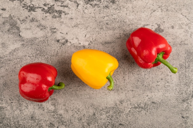 Colorful fresh bell peppers placed on stone surface