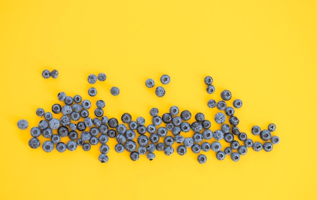 Colorful fruit pattern of blueberries on yellow background