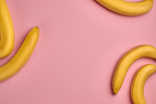 Colorful fruit pattern of fresh yellow bananas on pink