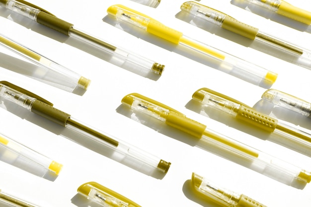 Colorful gel pens pattern on a white background for back to school toned illuminating yellow color