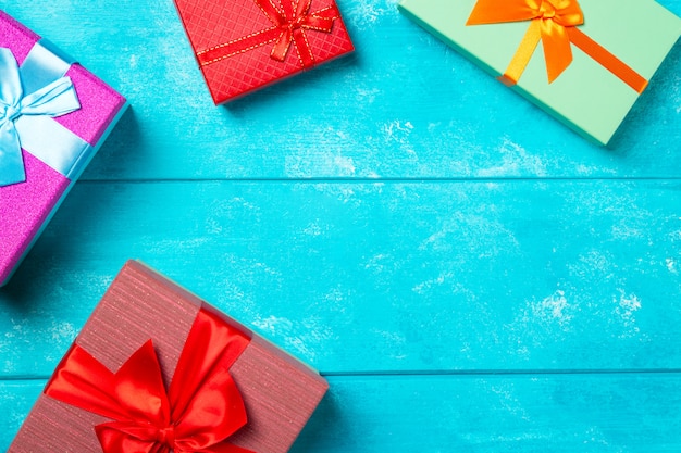 Colorful gift boxes with ribbons on nice blue wooden background