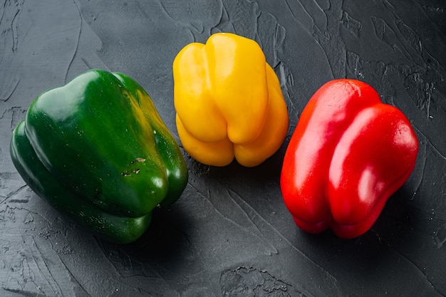 Colorful green , red and yellow peppers, on black background