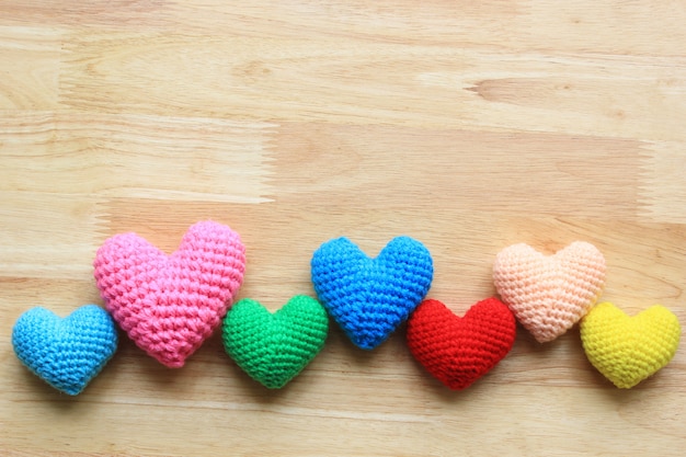 Colorful of Handmade crochet heart on wood table for valentines day with copyspace