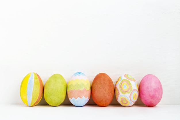 Colorful handmade Easter eggs on white background Esater eggs in row over white