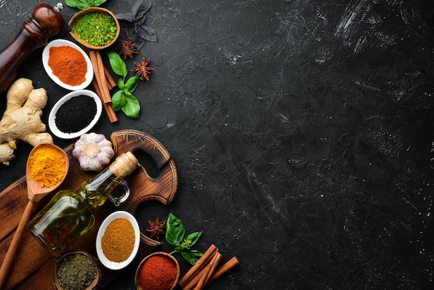 Colorful herbs and spices for cooking Indian spices On a black stone background Top view