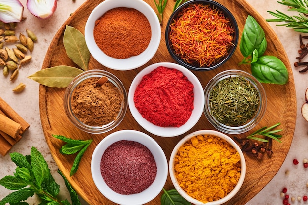 Colorful herbs and spices for cooking: turmeric, dill, paprika, cinnamon, saffron, basil and rosemary