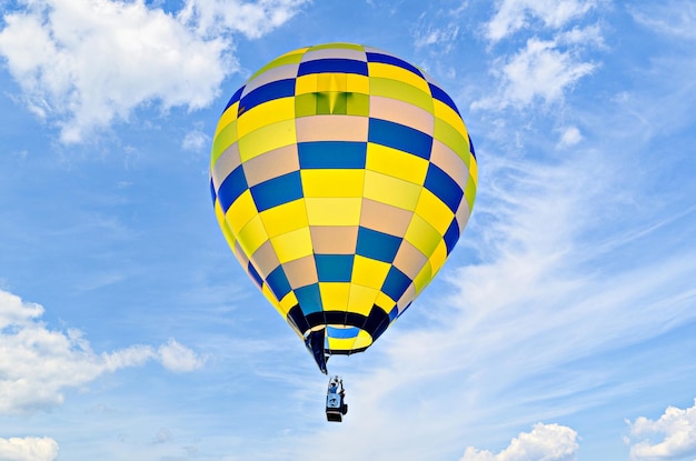 Colorful hot air balloon flying over blue sky.