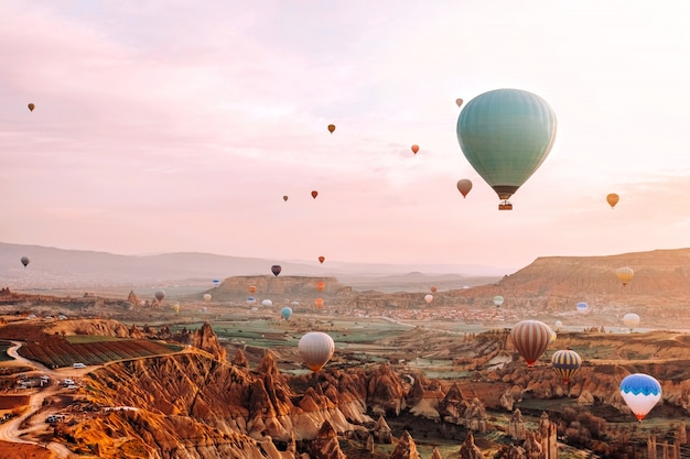 Colorful hot air balloons flying over the valley at Cappadocia sunrise 