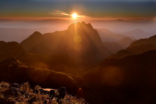 Colorful light beams from mountain top in sunset time