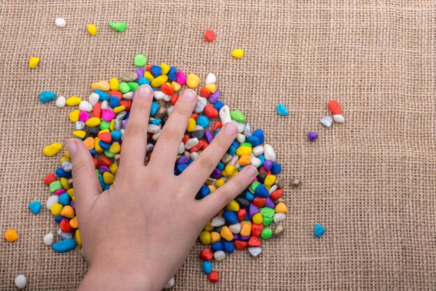 Colorful little pebbles in hand and on ground