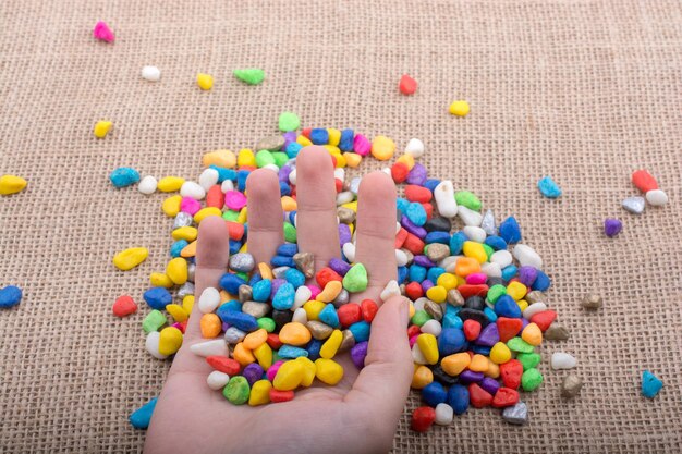 Colorful little pebbles in hand and on ground