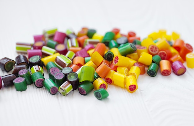 Colorful lollipops, candy canes and sweet candies mix on wooden background