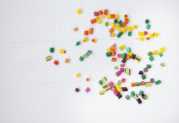 Colorful lollipops, candy canes and sweet candies mix on wooden background