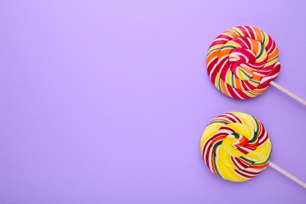 Colorful lollipops on purple table, sweets candy concept