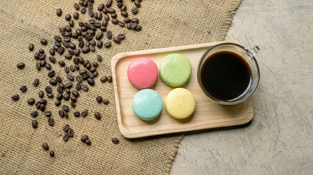 Colorful macaroons and a coffee on gray background.