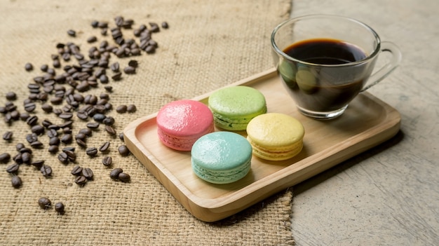 Colorful macaroons and a coffee on gray background.