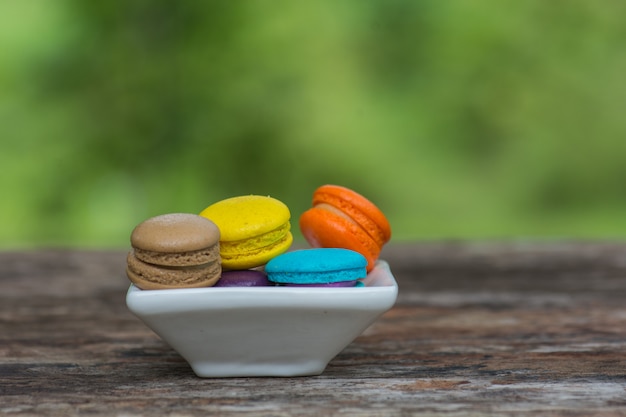 Colorful Macaroons in dish on wooden table