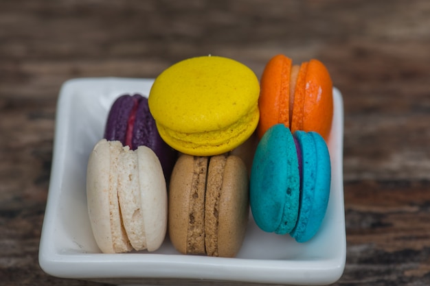 Colorful Macaroons in dish on wooden table