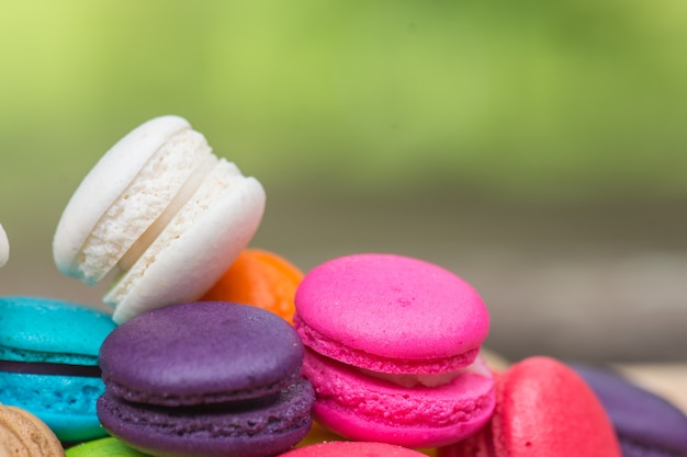 Colorful Macaroons in dish on wooden table