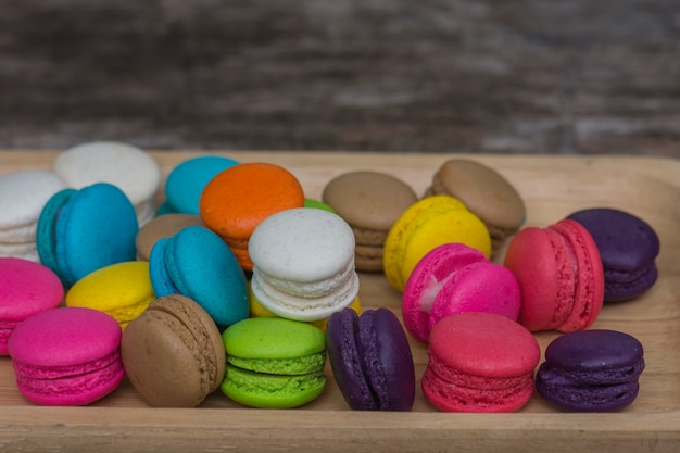 Colorful Macaroons in dish on wooden table