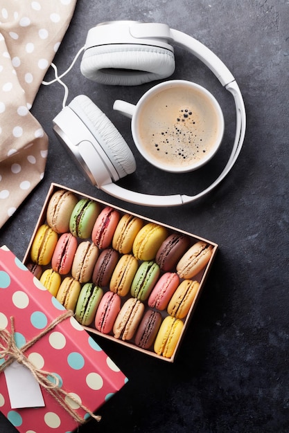 Colorful macaroons in a gift box and headphones