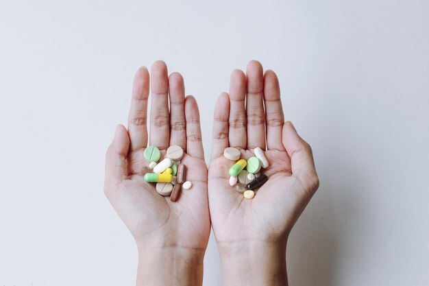 Photo colorful medicines on the hands isolated on white background minimalist and creative wallpaper