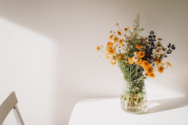 Colorful midsummer bunch of wildflowers in a vase on the table